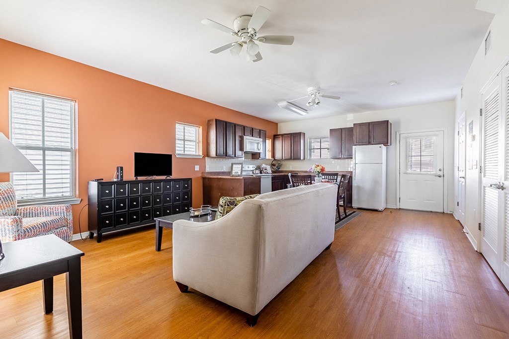 a living room and kitchen with a couch and a table at Marrero Commons Apartments & Townhomes