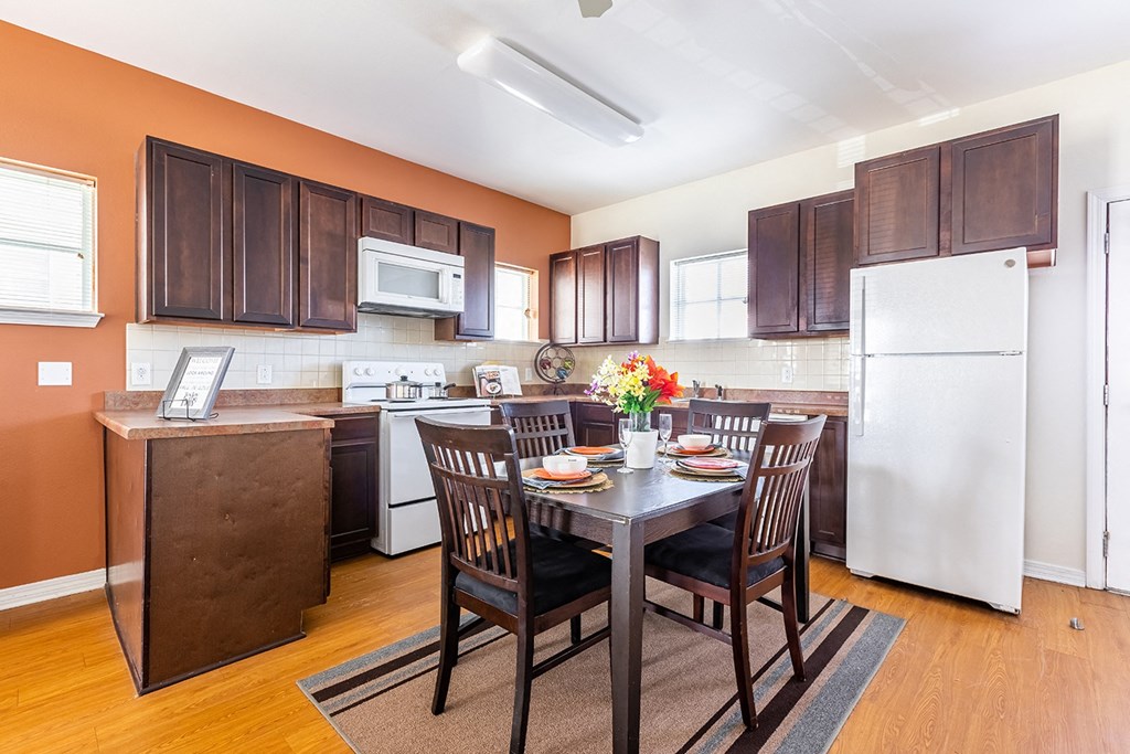 a kitchen and dining room with a table and chairs at Marrero Commons Apartments & Townhomes