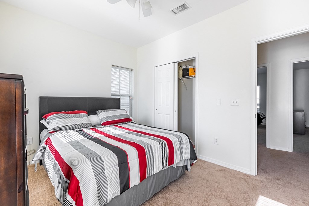 a bedroom with a bed and a closet at Marrero Commons Apartments & Townhomes