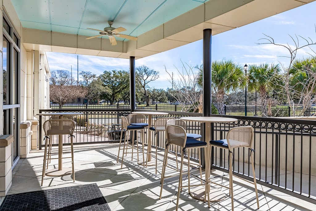 a covered patio with tables and chairs and a ceiling fan at Marrero Commons Apartments & Townhomes