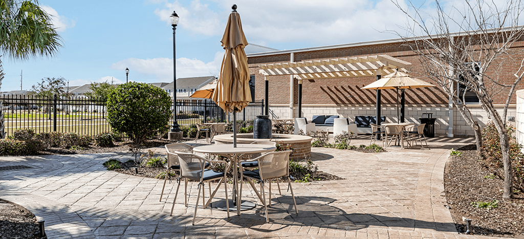 a patio with tables and umbrellas at Marrero Commons Apartments