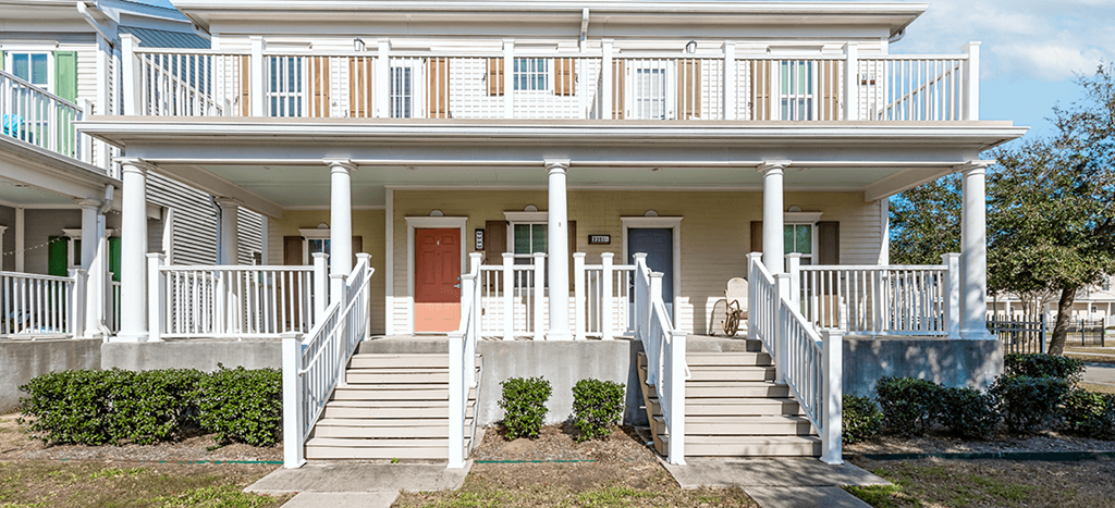 the front of a apartment homes with stairs and a porch at Marrero Commons