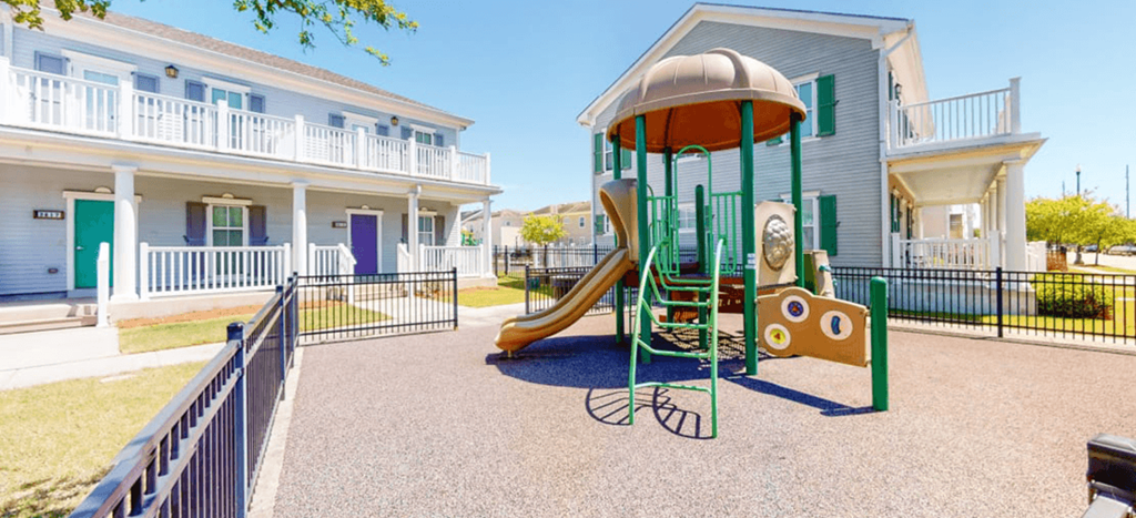 Marrero Commons playground with a slide in front of an apartment building