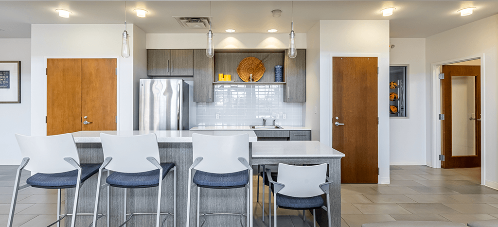 Marrero Commons apartments Clubhouse a kitchenette with a large island with white chairs