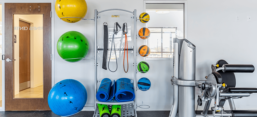 a gym with weights and exercise equipment on the wall at Marrero Commons Apartments