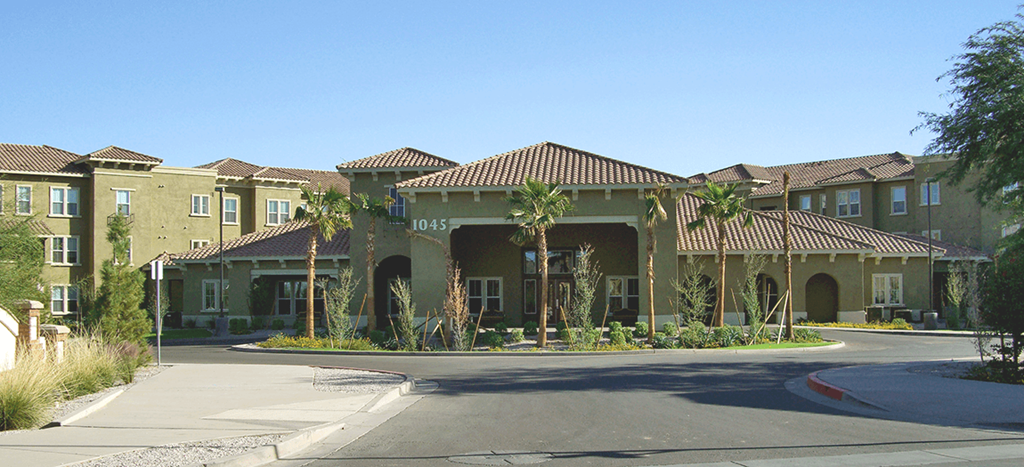 a senior apartment building with palm trees in front of it