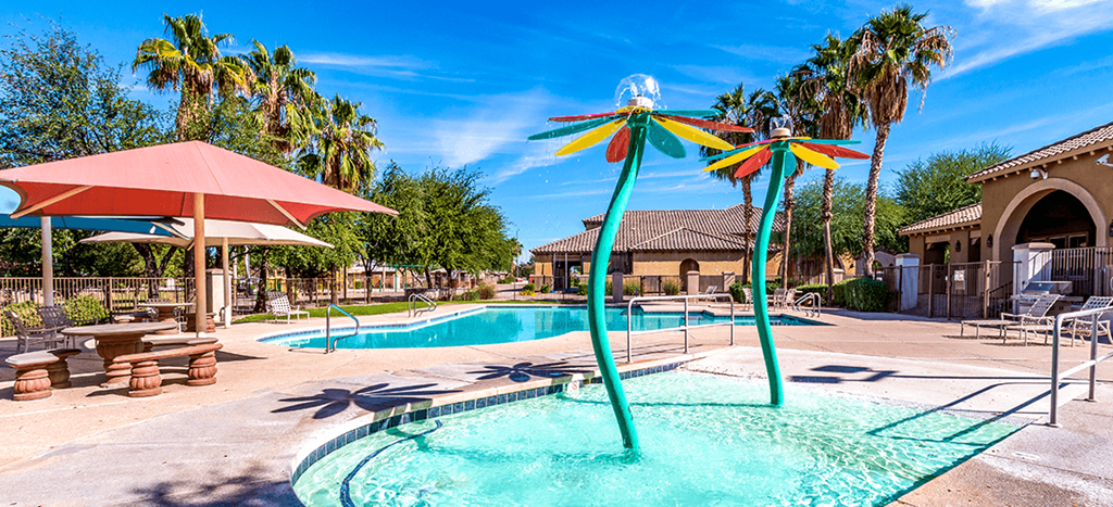 Pool area with a kiddie pool and multicolor flower fountains at Matthew Henson Apartments