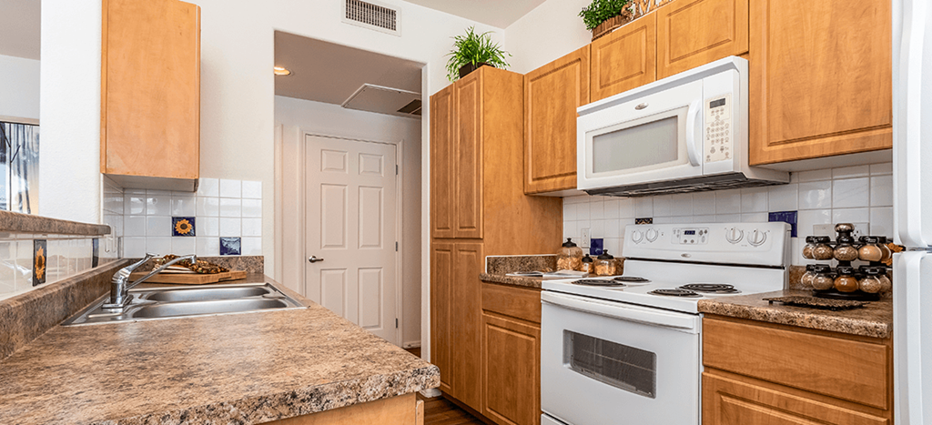 a kitchen with white appliances and counter tops