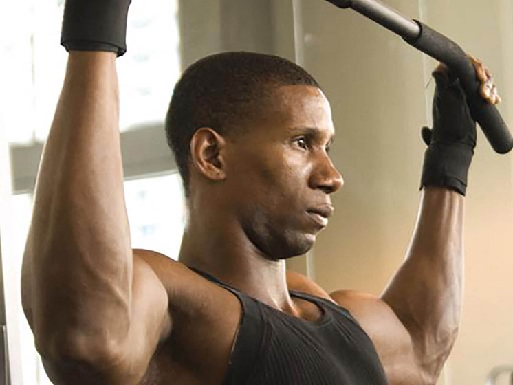 man using exercising machine at fitness center_Northpark at Scott Carver Apartments Miami, FL