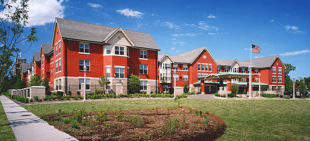 Orange apartment homes with an flag in front of them
