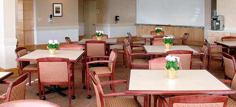 a dining room with tables and chairs and flowers