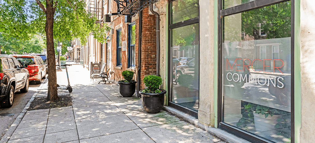 a city street with shops and trees on the sidewalk at Mercer Commons Apartments