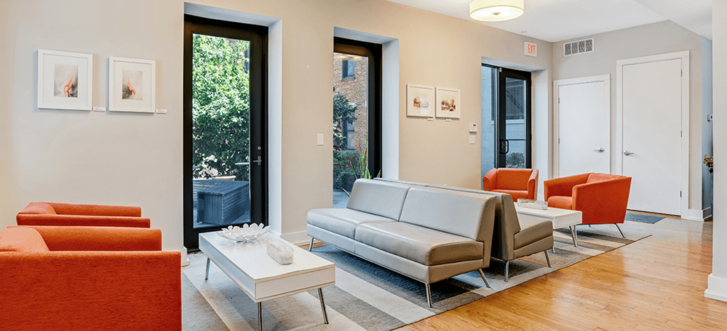Clubhouse with couches and chairs and a coffee table at Mercer Commons Apartments