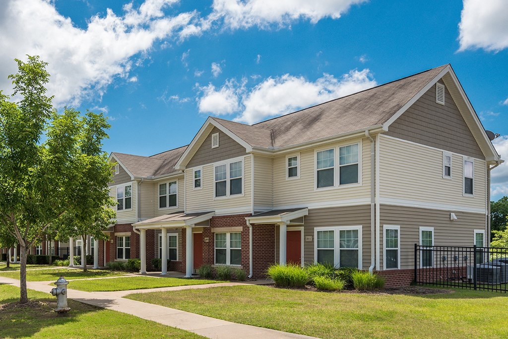 a row of houses with a sidewalk in front of them