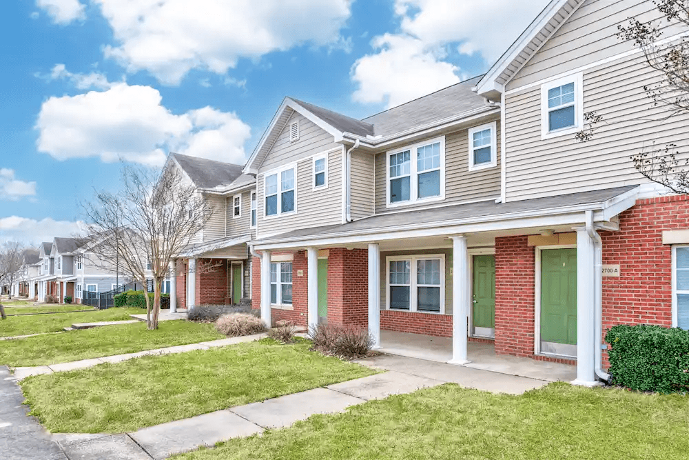 A row of houses with green front doors.