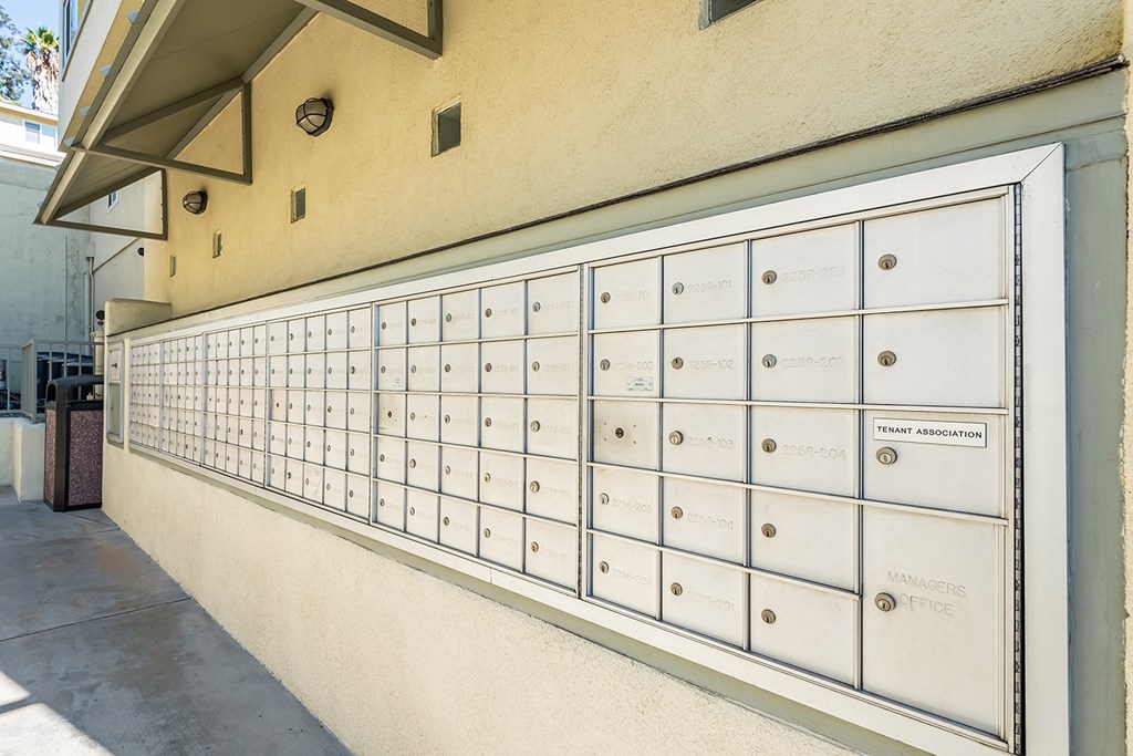 A row of mailboxes on a wall with the words "TENANT ASSOCIATION" and "MANAGERS OFFICES" written on them.