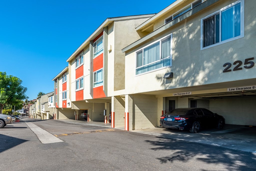 A black car is parked in the driveway of apartment 225.