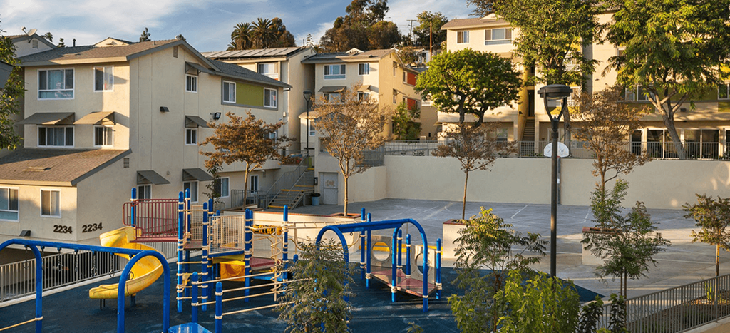 a playground surrounded by apartment buildings at Mission Plaza Apartments