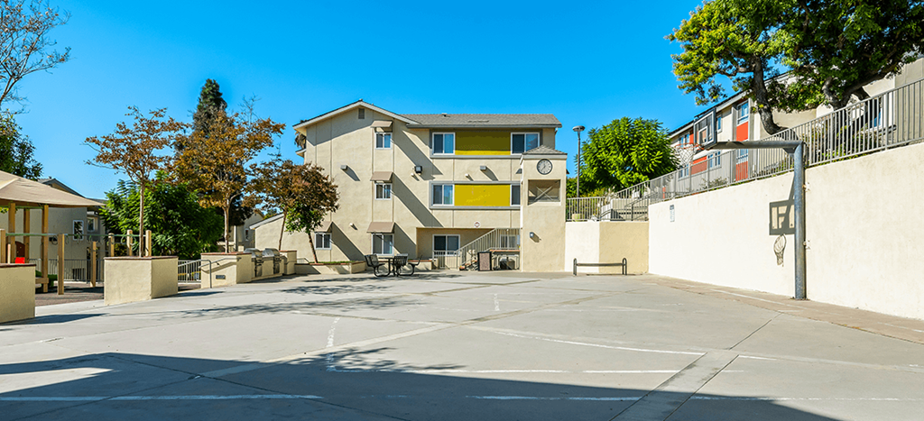 The sport court at Mission Plaza Apartments with a basketball court and hoop