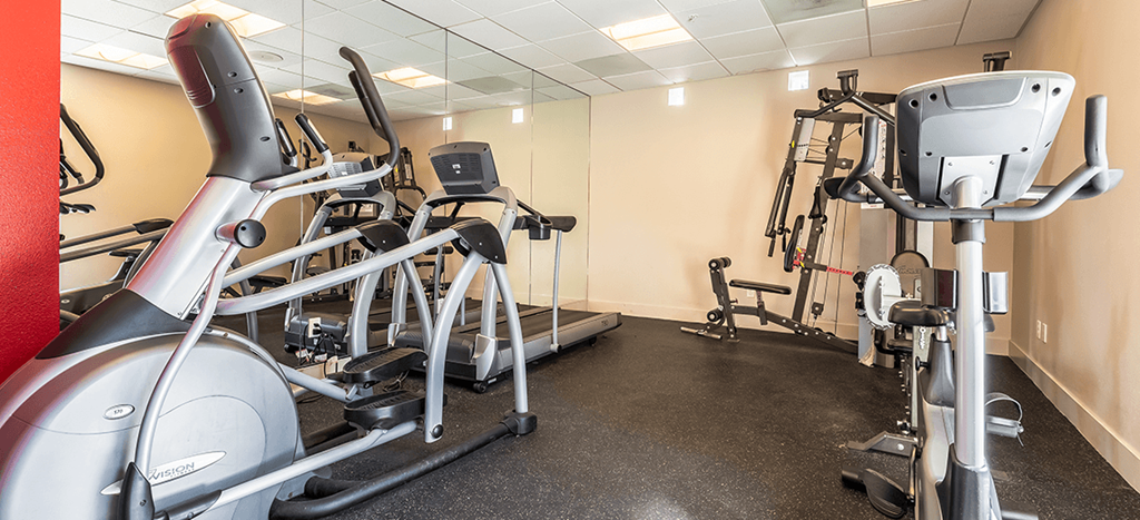 a gym with treadmills and other exercise equipment at Mission Plaza Apartments