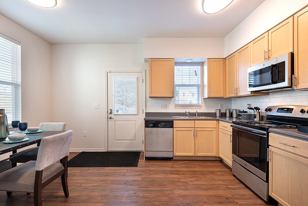 a kitchen with wooden cabinets and a stove and a microwave