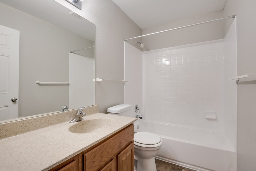 A white bathroom with a toilet, sink, and bathtub.