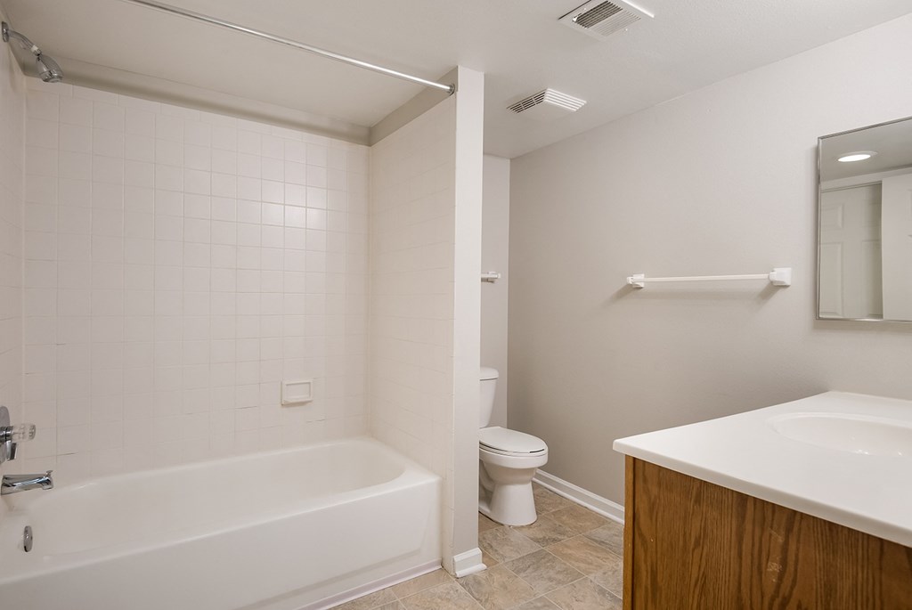 A white bathroom with a tub, toilet, and sink.