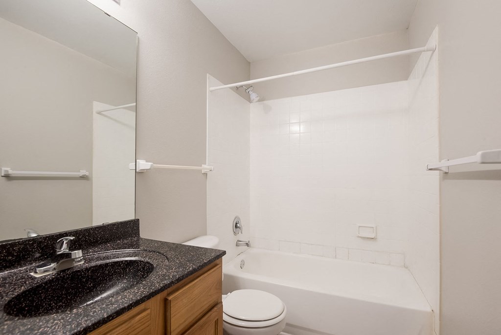 A bathroom with a sink, toilet, and bathtub.