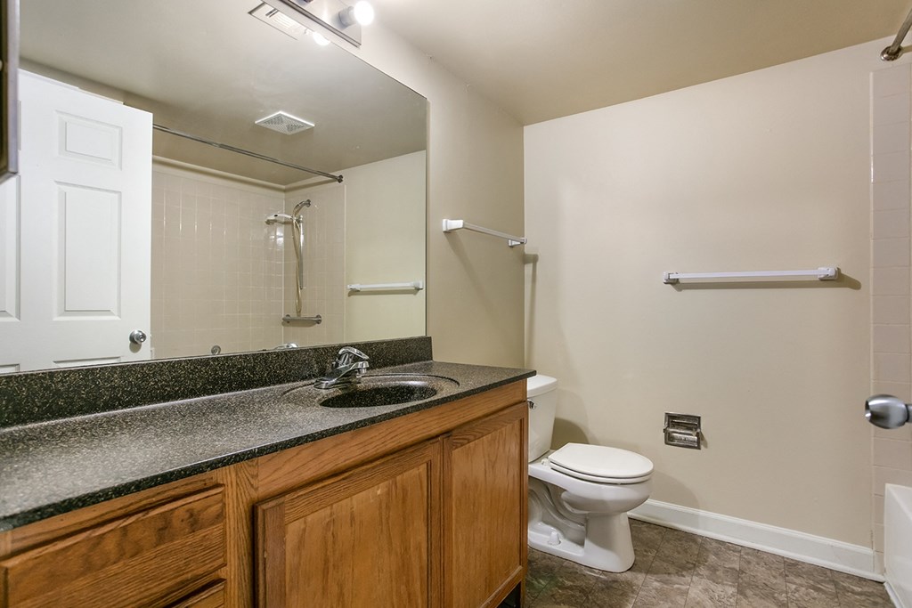 A bathroom with a toilet, sink, and shower.