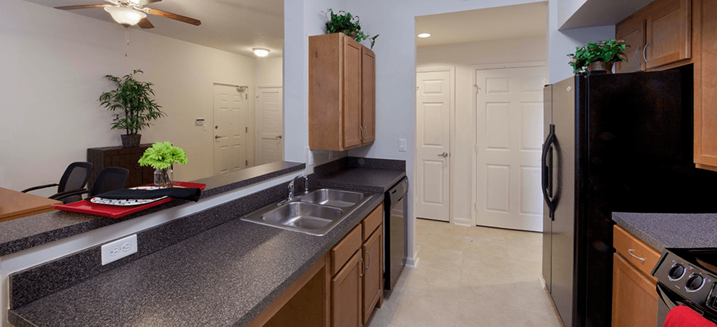 a kitchen with a granite counter top and a stainless steel refrigerator