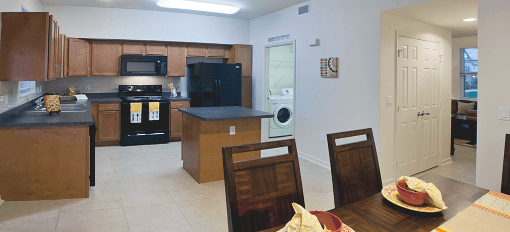 a kitchen and dining room with a table and chairs at Northpark at Scott Carver Apartments