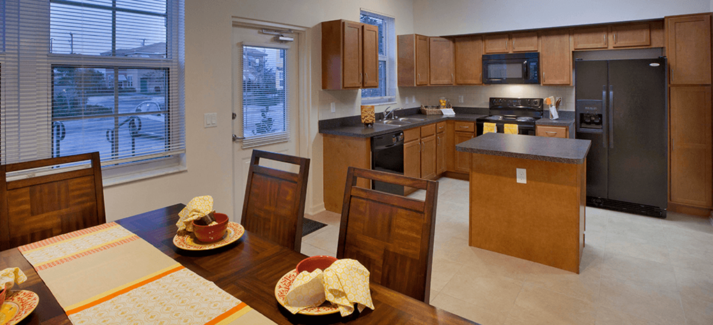 a kitchen with wooden cabinets and a table with plates on it