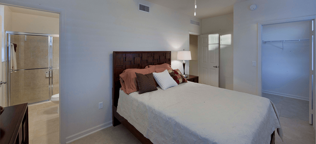 a bedroom with a bed and a bathroom with a shower