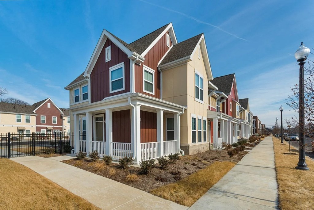a row of houses with a sidewalk in front of them