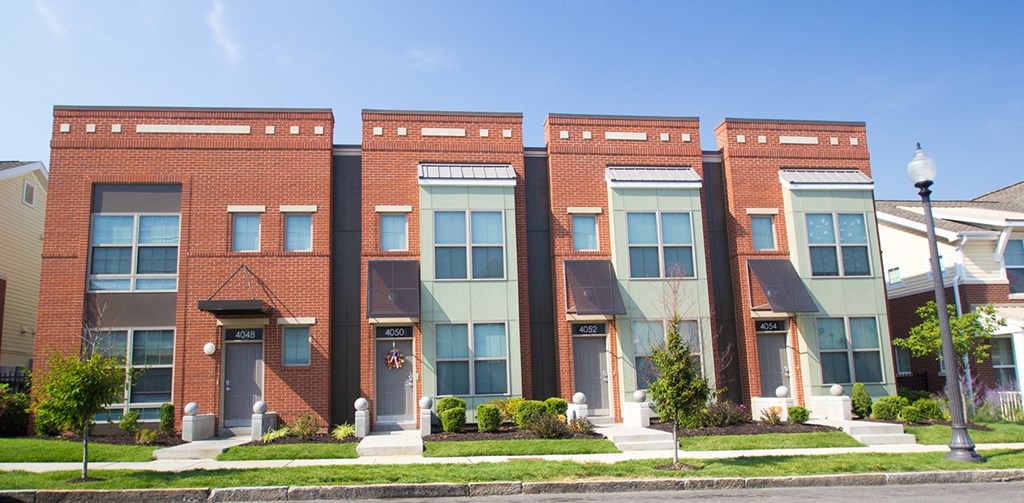 a row of brick apartment buildings on the side of a street