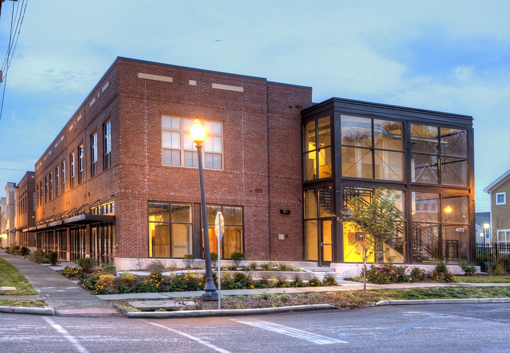 a red brick building with large windows on a city street