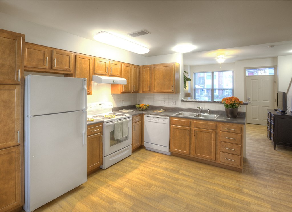 a kitchen with white appliances and wooden cabinets