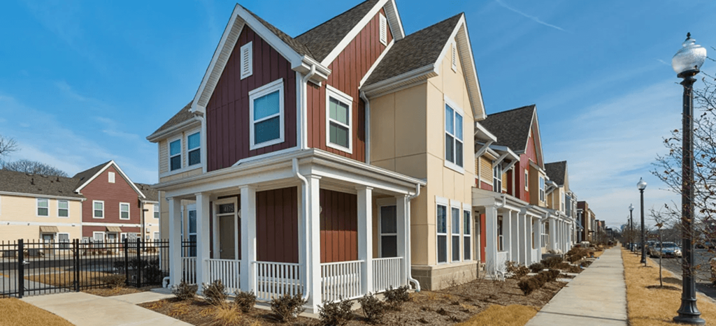 a row of townhomes with red and white roofs and a sidewalk