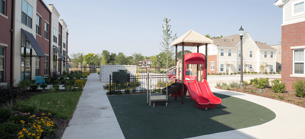 a playground with a red slide in front of North Sarah Apartments