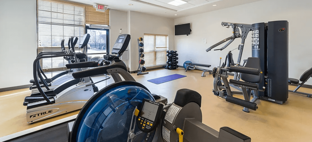 a gym with cardio equipment and weights in a building