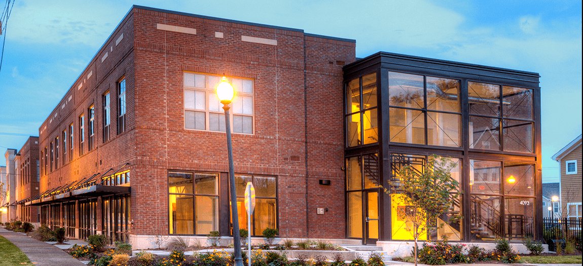 a large brick apartment building with large windows and a street light