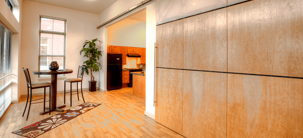 a kitchen with a refrigerator and a dining room with a table and chairs at North Sarah Apartments