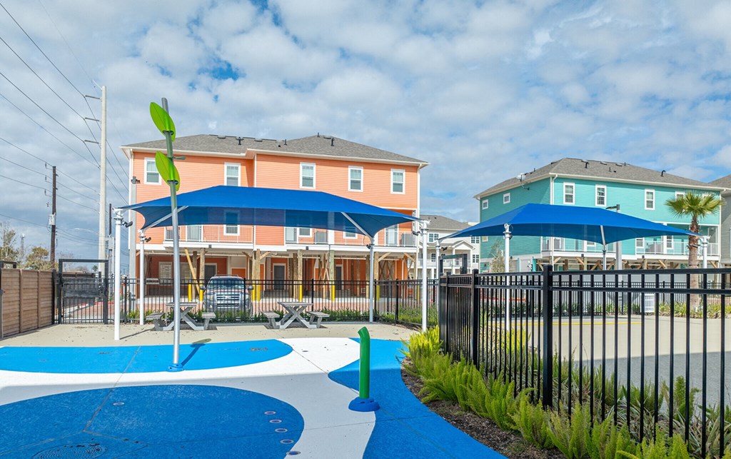 our apartments have a playground with a swing set and umbrellas
