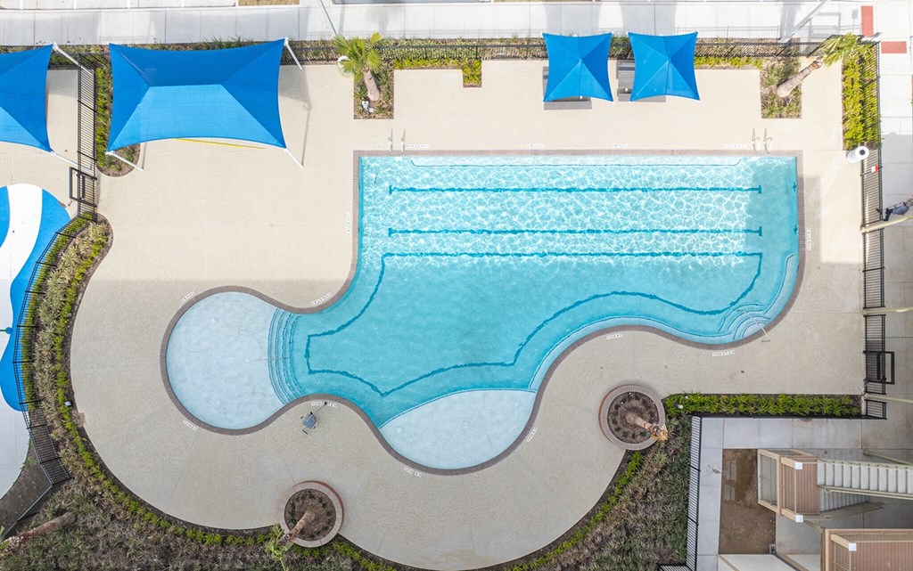 an aerial view of a swimming pool with umbrellas