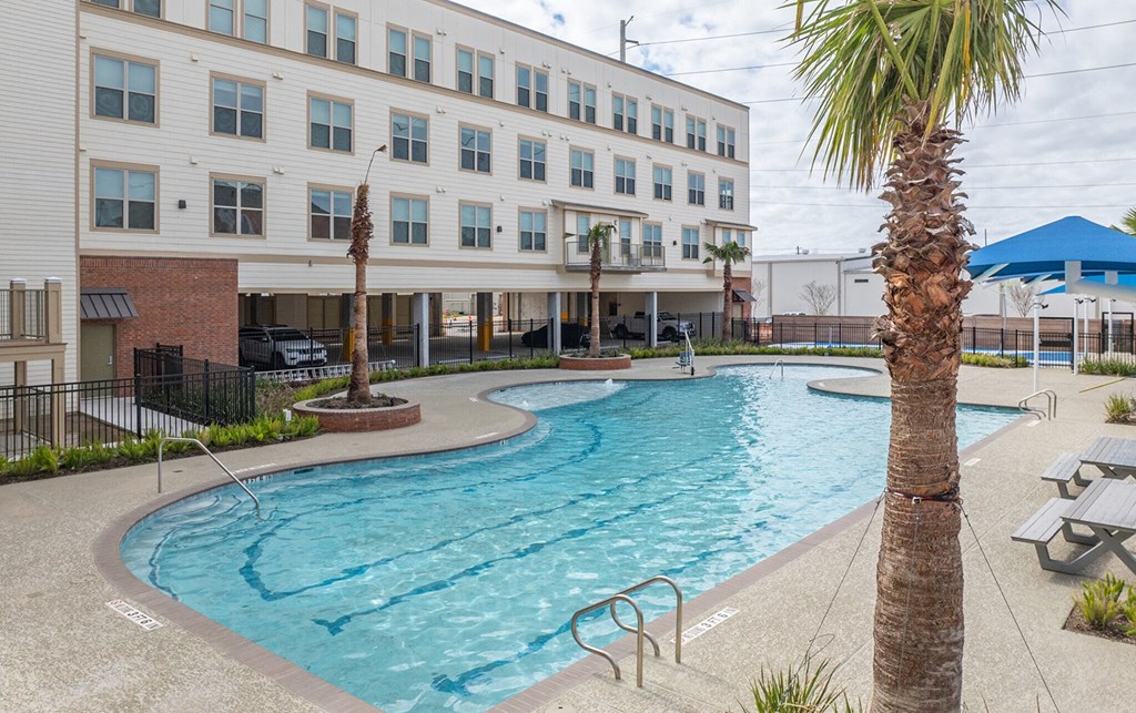 a resort style swimming pool with a building in the background