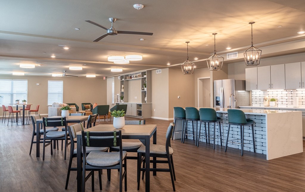 a large dining room with tables and chairs and a kitchen