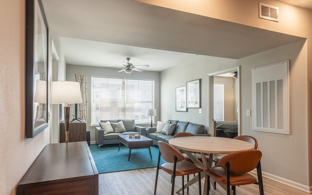 a living room and dining room with a table and chairs