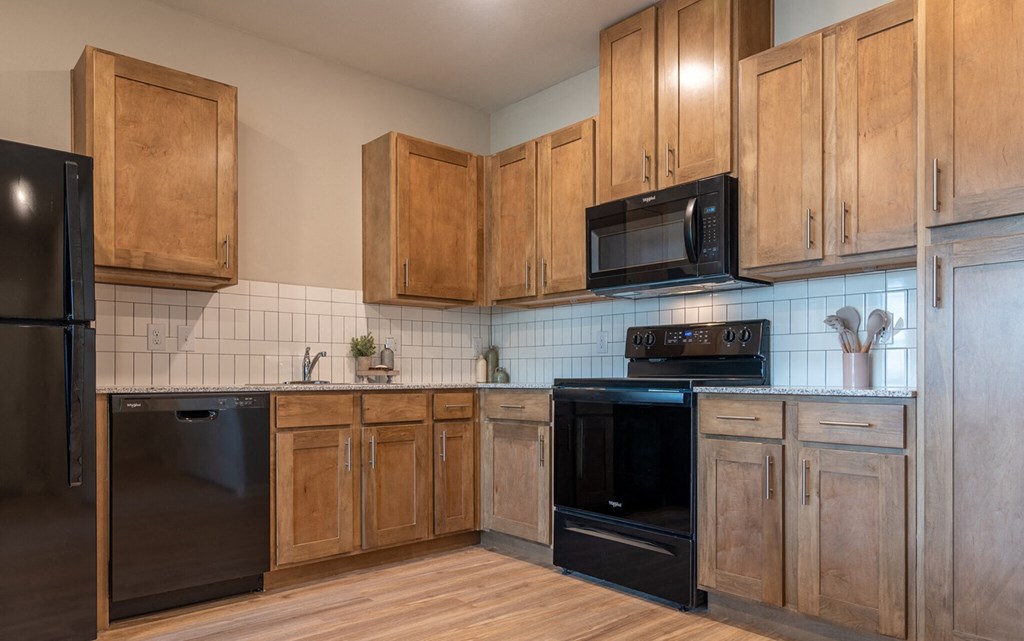 a kitchen with black appliances and wooden cabinets