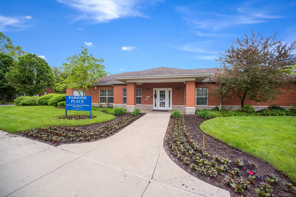 a building with a sidewalk and a blue sign in front of it