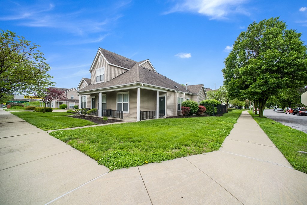 a house on the corner of a street with a sidewalk